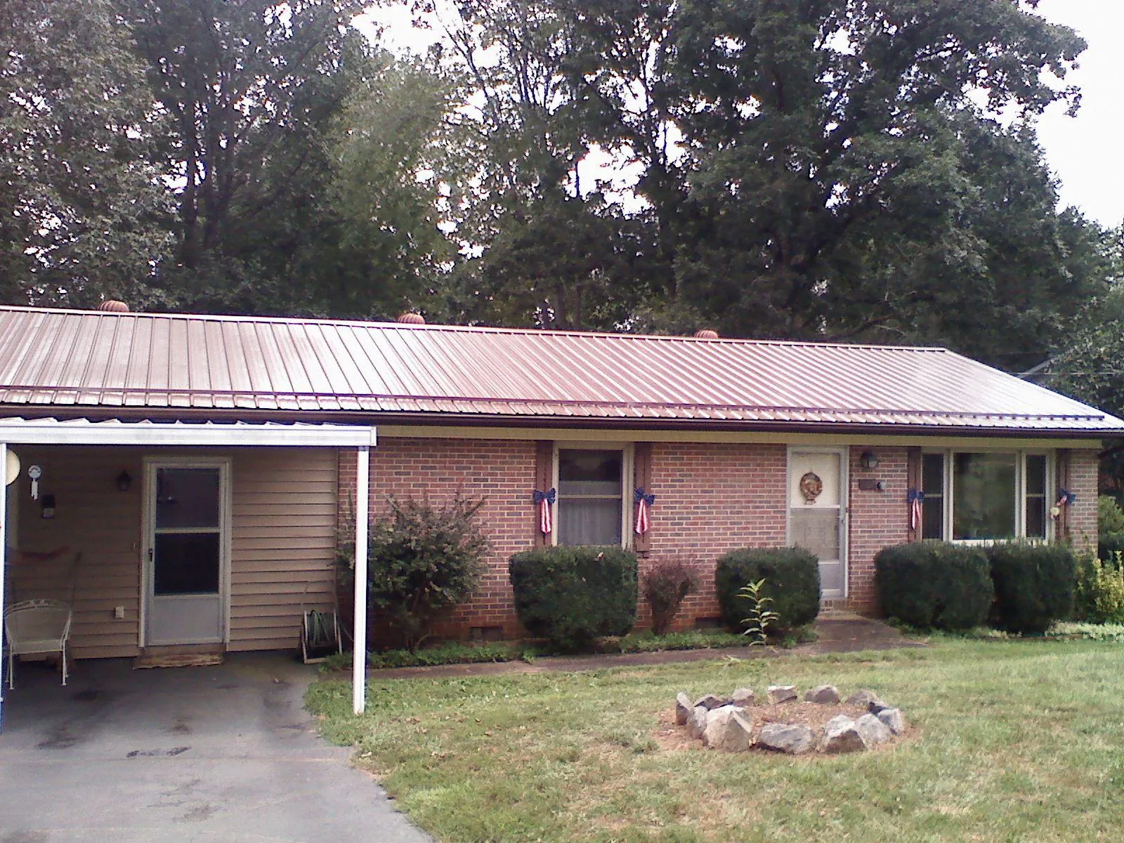 Bronze metal roof and carport on a brick ranch home — Roof Repair work by our crew in Salkum